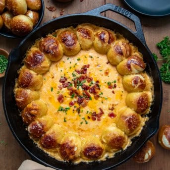 Pretzel Beer Cheese Dip in a skillet on a wooden table from overhead.