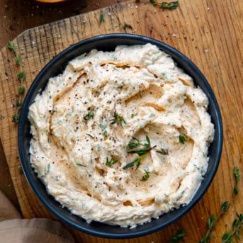 Black bowl filled with Cowboy Cream Cheese on a cutting board.